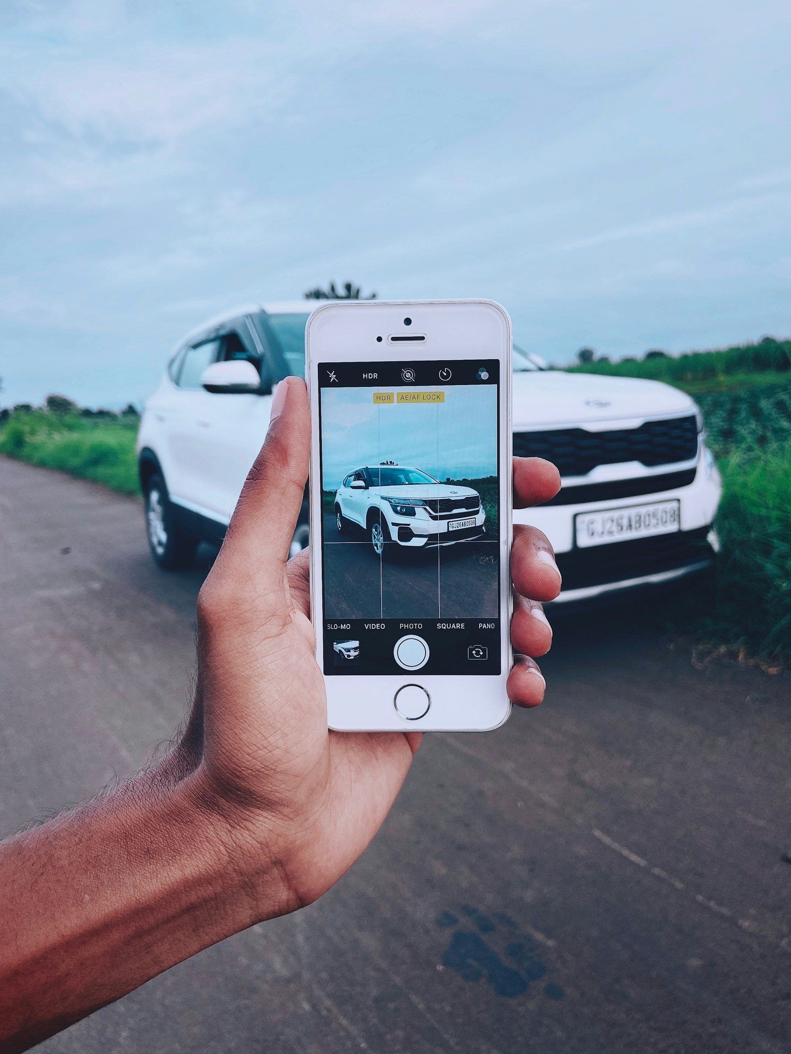 Een handelaar fotografeert een auto met zijn telefoon
